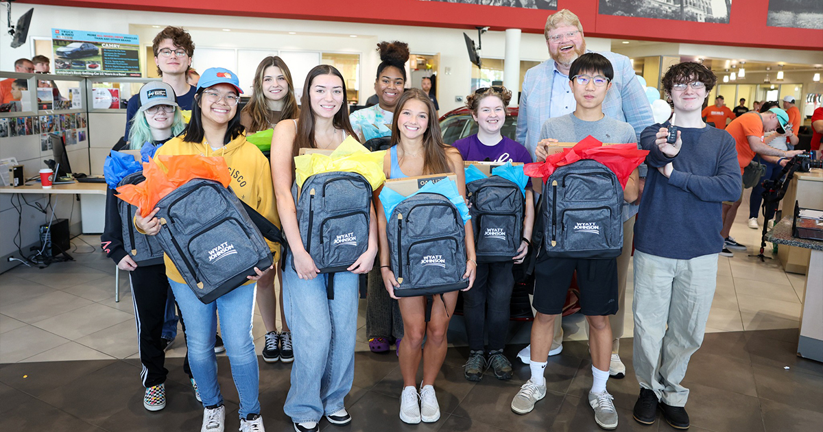 Students at the Wyatt Johnson Toyota dealership holding up their new Wyatt Johnson supplied backpacks