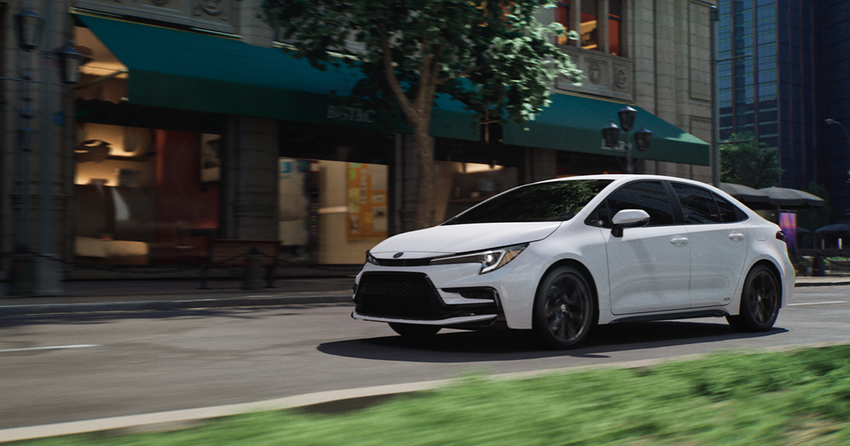 A white Toyota Corolla driving through city streets.